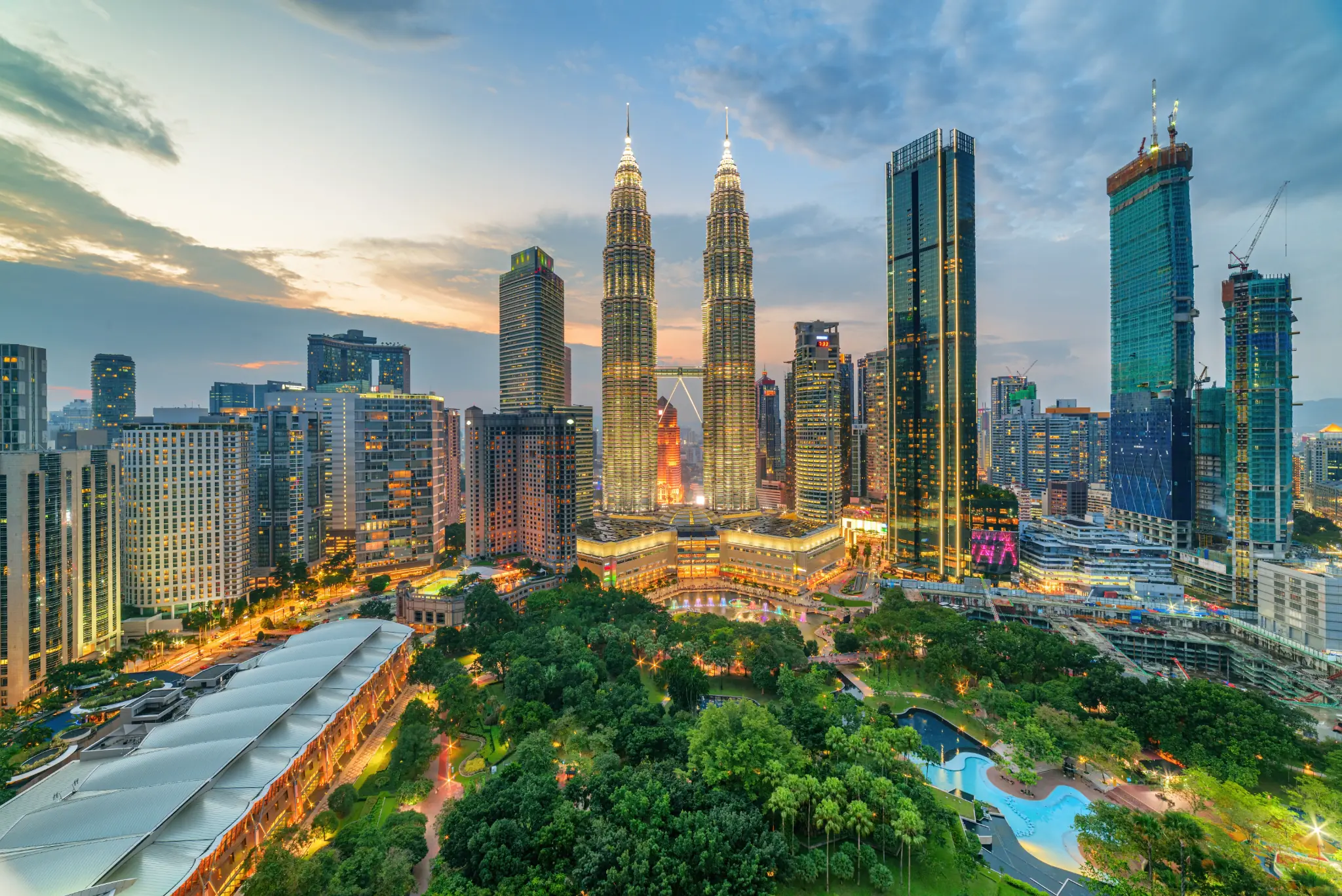 Petronas Twin Towers in Kuala Lumpur at dusk with city skyline and KLCC Park